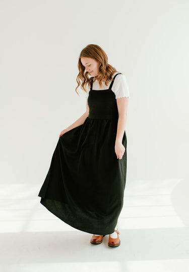 black inch wide strap jumper with ankle length and form fitting bodice.