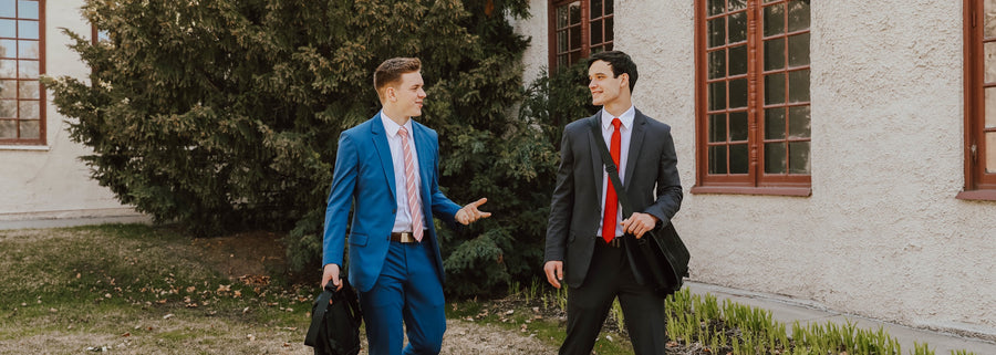 Two elders in suits and ties walking outside